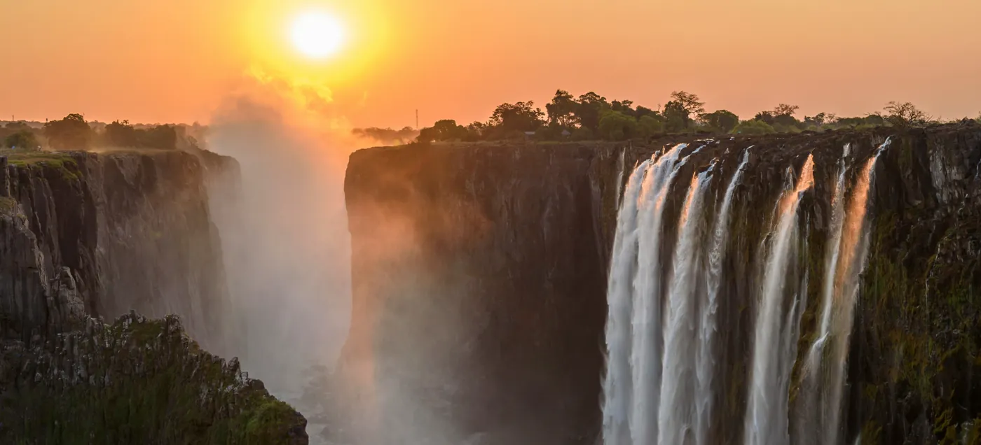 Victoria Falls at golden hour with spray in the evening light