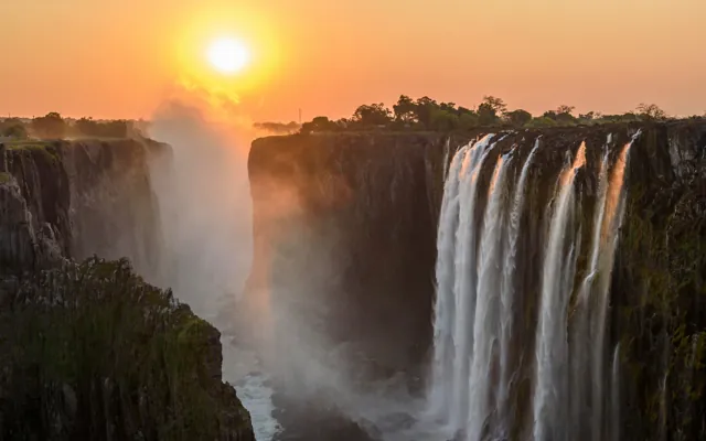 Victoria Falls at golden hour with spray in the evening light